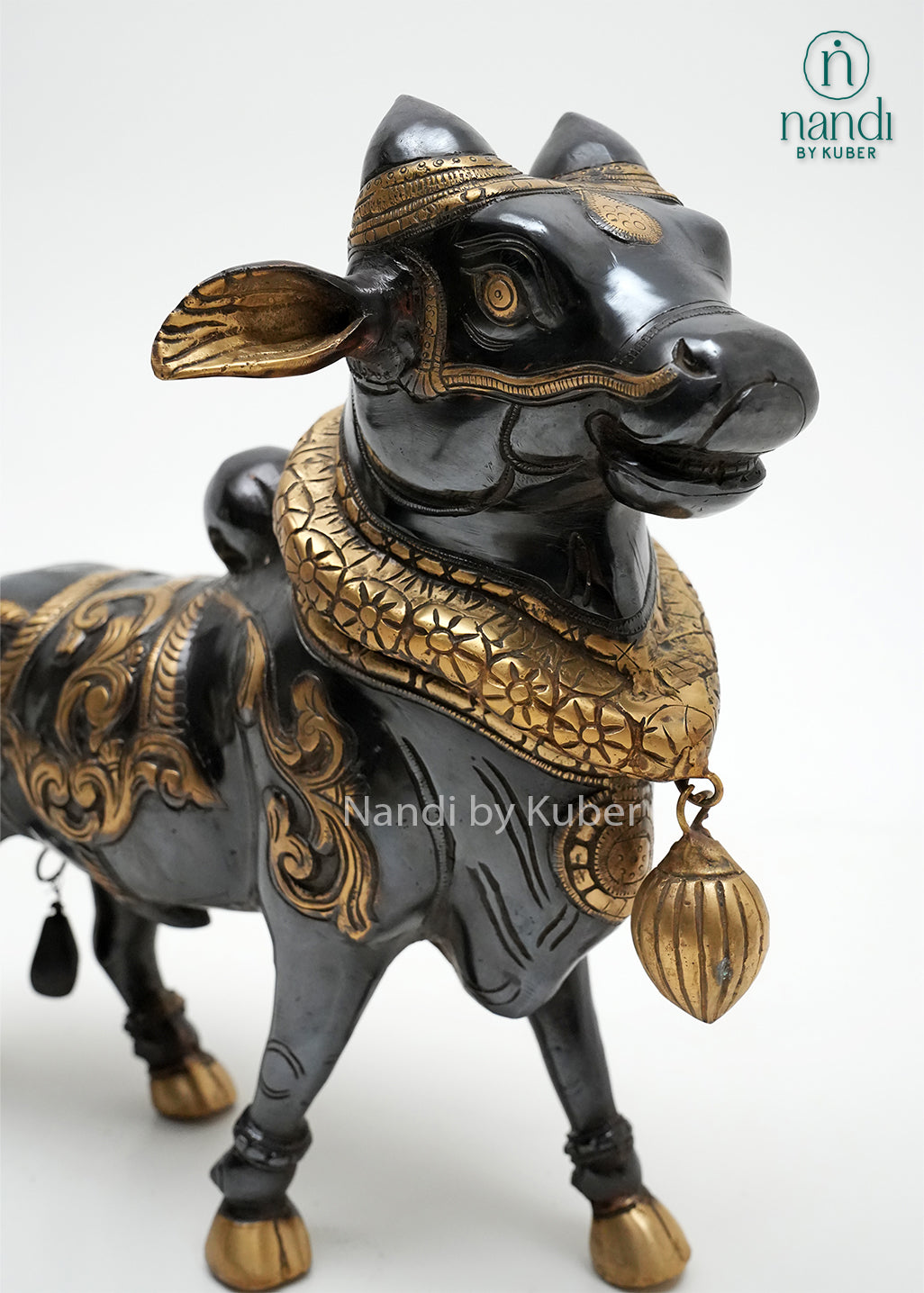 Handcrafted Nandi bull figurine with black and gold detailing, traditional ornamental carvings, and decorative pendant, ideal for spiritual décor, temple-inspired interiors, and collectible displays.